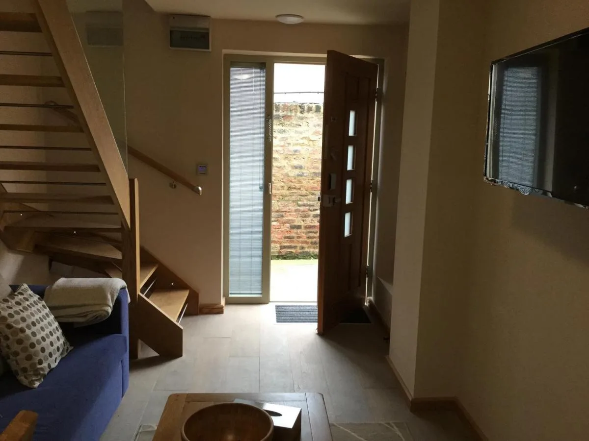 a living room with a blue couch and a sliding door at York Aparthotel in York