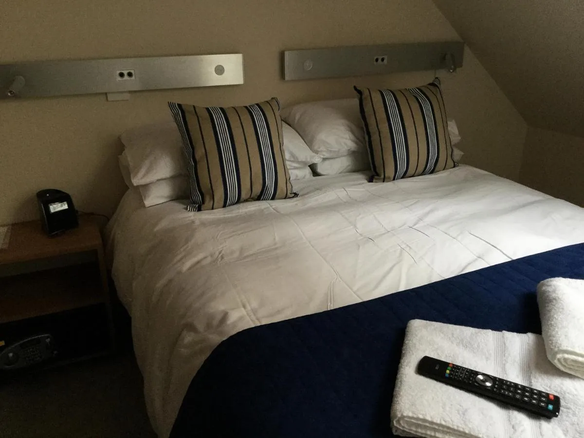 a large white bed with pillows in a room at York Aparthotel in York