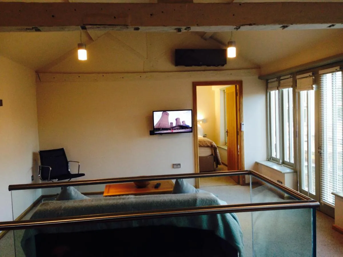 a living room with a couch and a tv on the wall at York Aparthotel in York