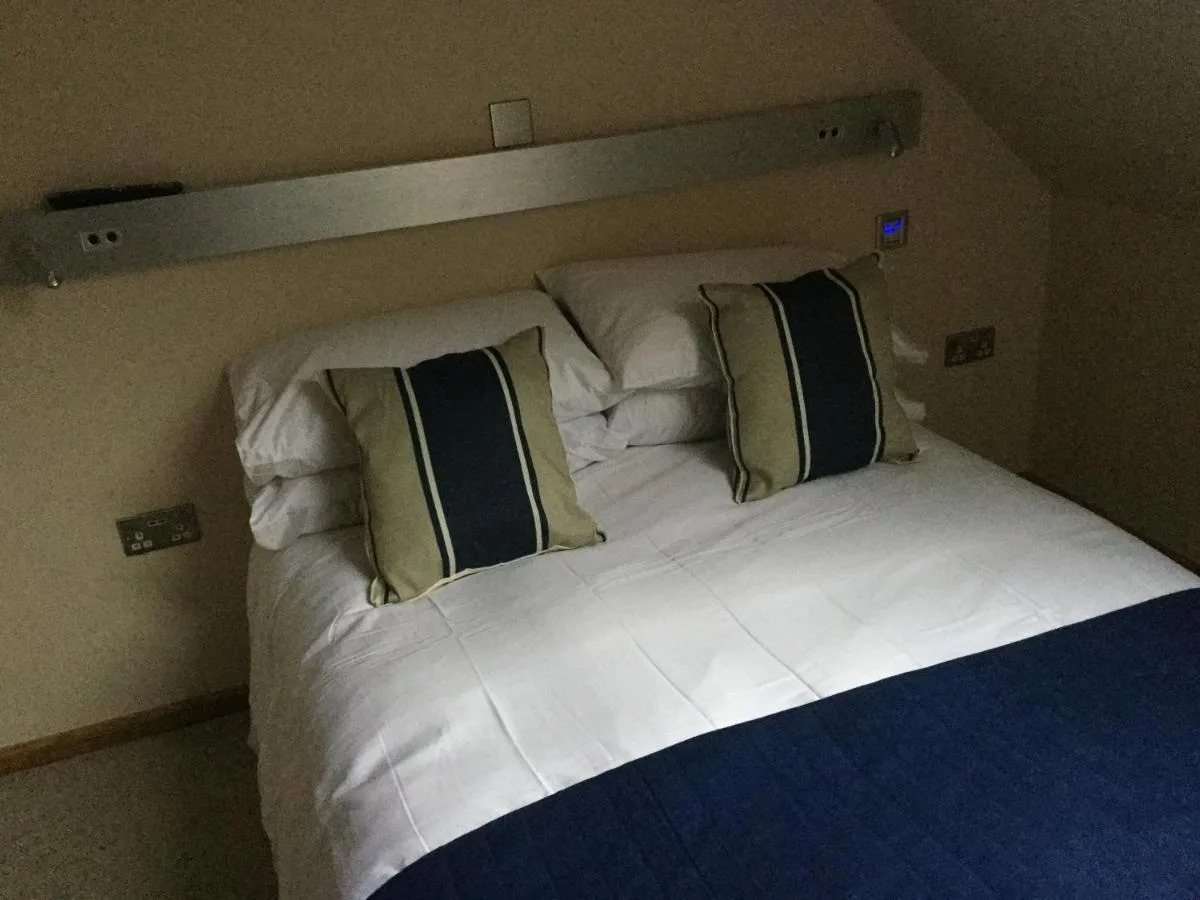 a large white bed with two pillows on it at York Aparthotel in York